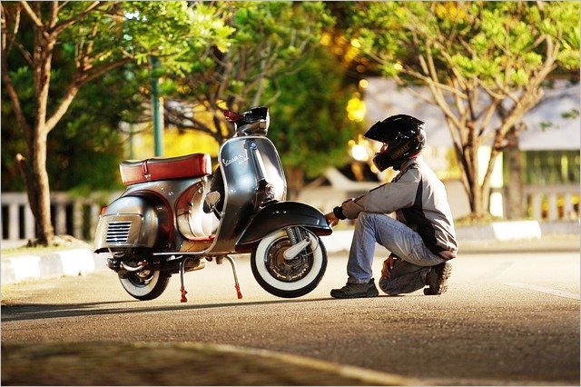 バイクにお別れしている風の青年